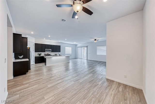 living room featuring a ceiling fan, recessed lighting, visible vents, and light wood-style floors