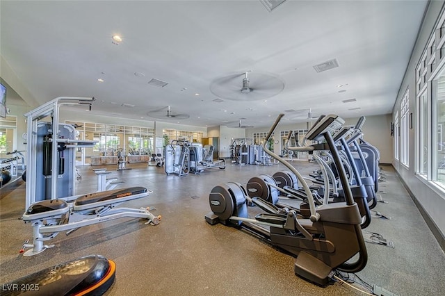 workout area with a ceiling fan, a wealth of natural light, and visible vents