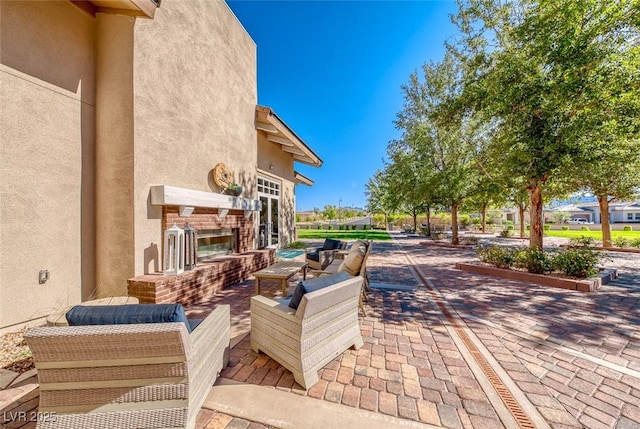 view of patio with an outdoor living space with a fireplace