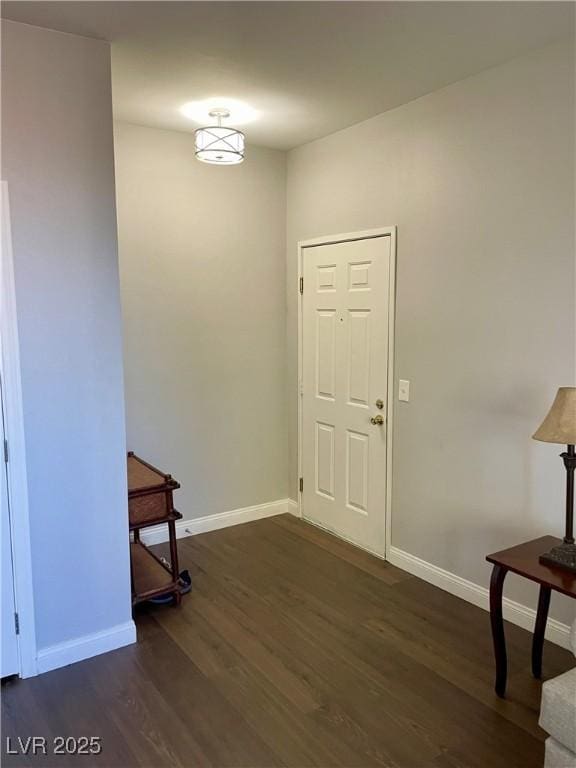 foyer featuring dark wood finished floors and baseboards