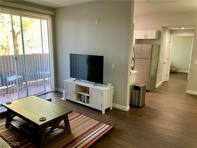 living area with baseboards and dark wood-style flooring