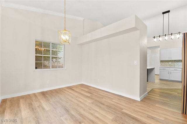 unfurnished dining area with light wood finished floors, baseboards, a notable chandelier, and ornamental molding