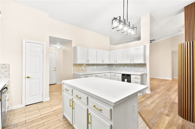 kitchen with white cabinetry, light countertops, hanging light fixtures, a center island, and tasteful backsplash