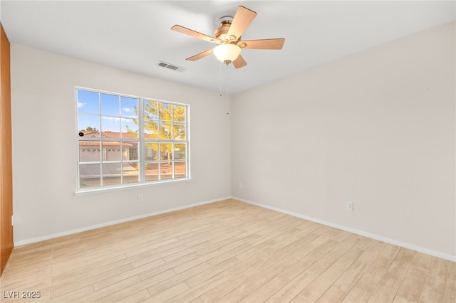 spare room featuring ceiling fan, light wood finished floors, visible vents, and baseboards