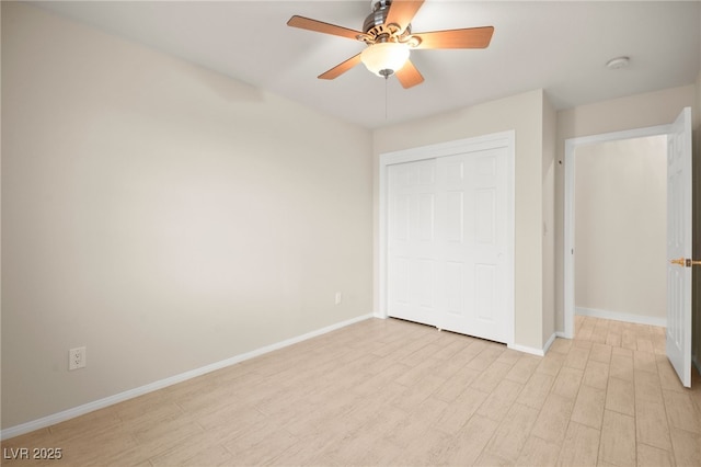 unfurnished bedroom featuring light wood finished floors, a ceiling fan, baseboards, and a closet