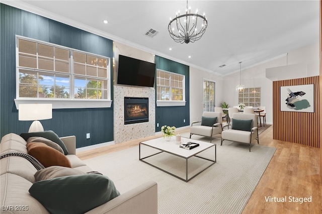 living room with a notable chandelier, a fireplace, light wood finished floors, lofted ceiling, and visible vents