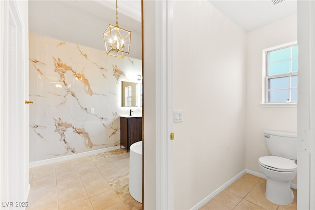 bathroom featuring an inviting chandelier, vanity, baseboards, and tile patterned floors