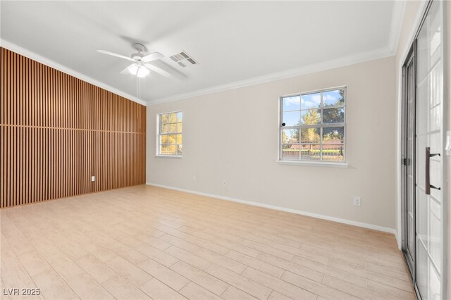 empty room featuring plenty of natural light, visible vents, and crown molding