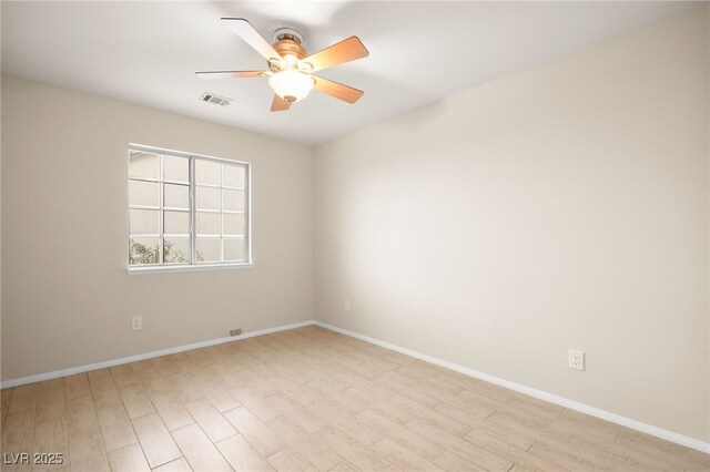 unfurnished room featuring baseboards, ceiling fan, visible vents, and light wood finished floors