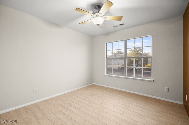 unfurnished room with baseboards, visible vents, and ceiling fan