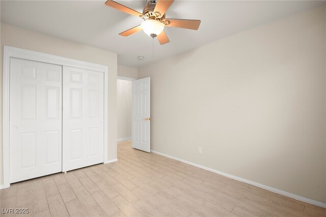 unfurnished bedroom featuring a ceiling fan, light wood-style flooring, baseboards, and a closet