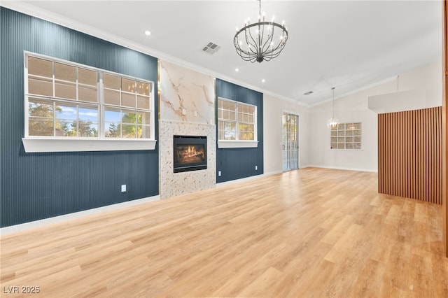 unfurnished living room with ornamental molding, plenty of natural light, visible vents, and a notable chandelier