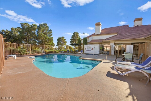 community pool featuring a patio area and fence