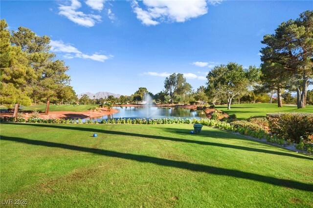 view of property's community with a yard and a water and mountain view