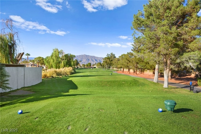 view of home's community featuring fence, a mountain view, and a yard