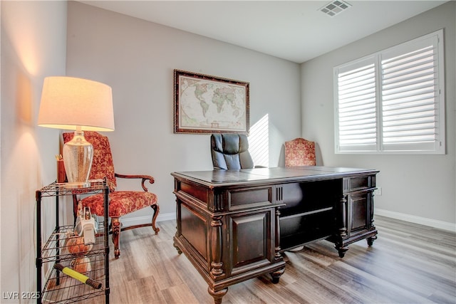 office space featuring baseboards, visible vents, and light wood-style floors