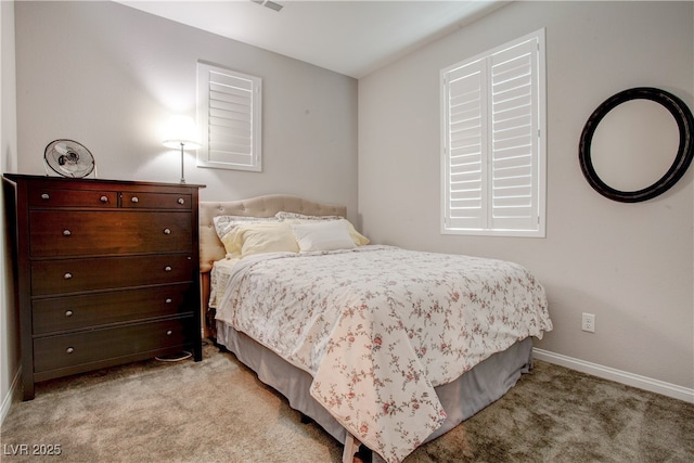 bedroom with baseboards and light colored carpet