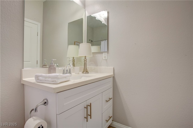 bathroom with a textured wall and vanity