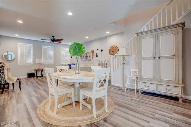 dining space featuring light wood-style floors, recessed lighting, baseboards, and stairs