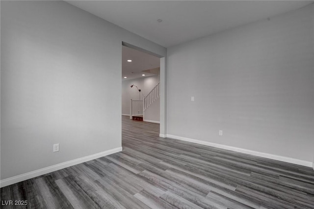 spare room featuring baseboards, stairs, dark wood finished floors, and recessed lighting