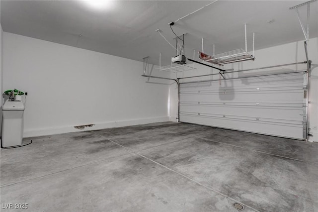 garage with baseboards and a garage door opener