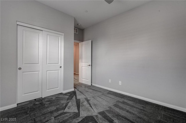 unfurnished bedroom featuring carpet flooring, baseboards, a closet, and visible vents