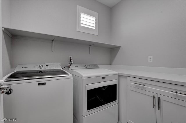 clothes washing area with washing machine and clothes dryer and cabinet space
