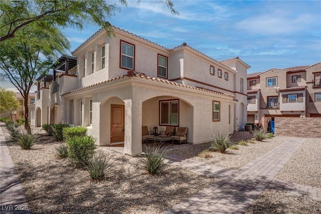 back of property with an outdoor hangout area, stucco siding, and a residential view