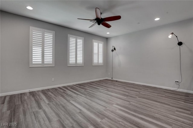 empty room with ceiling fan, recessed lighting, baseboards, and wood finished floors