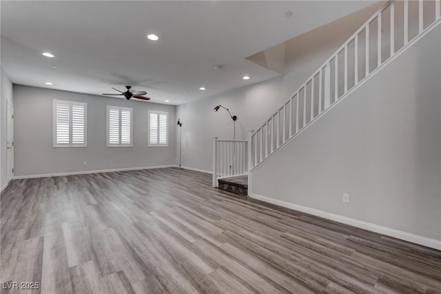 unfurnished living room featuring a ceiling fan, baseboards, recessed lighting, and wood finished floors