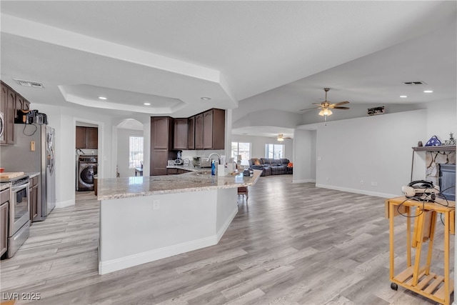 kitchen featuring washer / dryer, visible vents, appliances with stainless steel finishes, and open floor plan