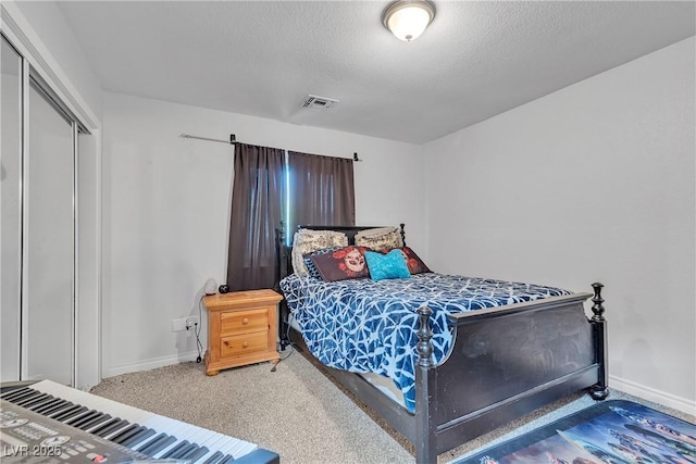 bedroom with carpet floors, baseboards, visible vents, and a textured ceiling