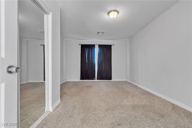 unfurnished room with light carpet, visible vents, and baseboards