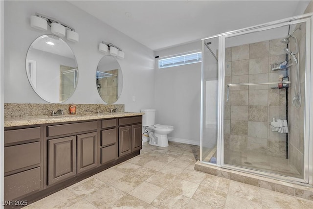 bathroom featuring a sink, a shower stall, toilet, and double vanity