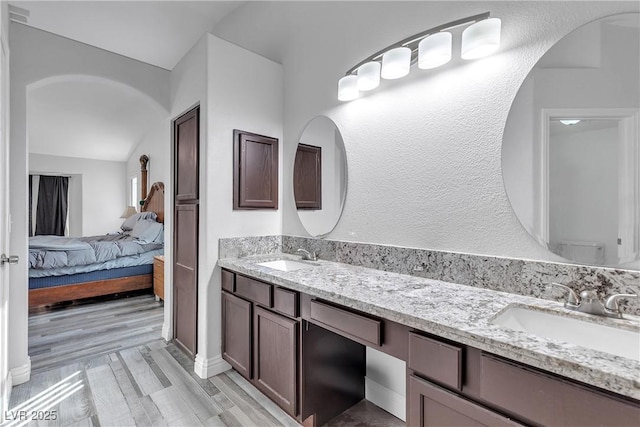 ensuite bathroom featuring wood finished floors, a sink, toilet, and ensuite bathroom