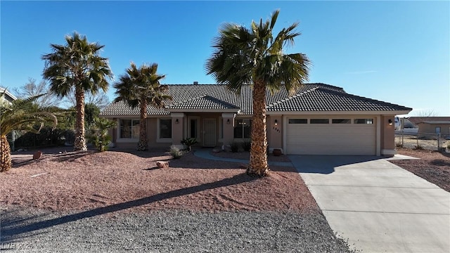 single story home with driveway, an attached garage, a tiled roof, and stucco siding