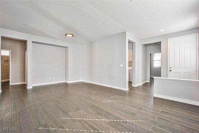 spare room with baseboards, dark wood-type flooring, and recessed lighting