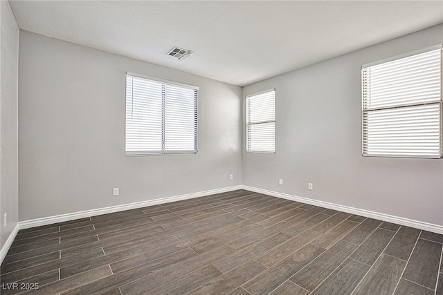 spare room featuring baseboards, visible vents, and wood tiled floor