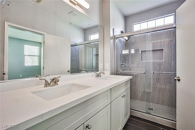 bathroom with a stall shower, plenty of natural light, and a sink