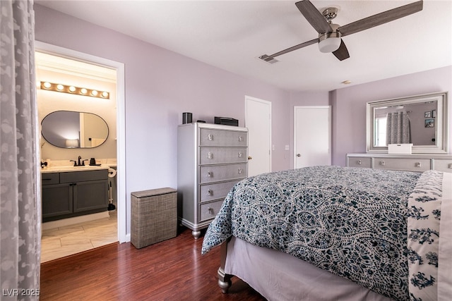 bedroom with dark wood-style flooring, visible vents, ensuite bathroom, a ceiling fan, and a sink