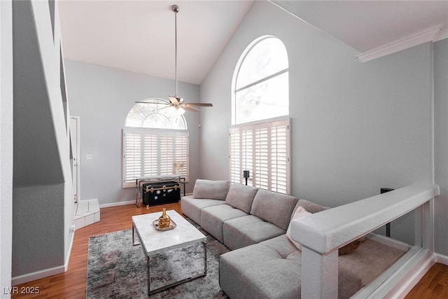 living area featuring ceiling fan, high vaulted ceiling, wood finished floors, and baseboards