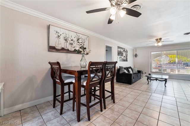 dining room with light tile patterned floors, baseboards, visible vents, and crown molding