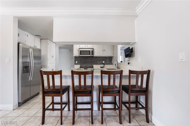 interior space featuring light countertops, appliances with stainless steel finishes, a sink, and white cabinets