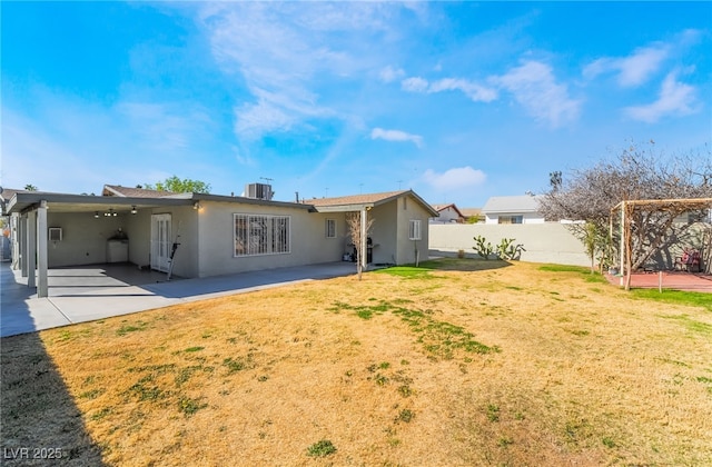 back of property with a yard, a patio area, a fenced backyard, and stucco siding