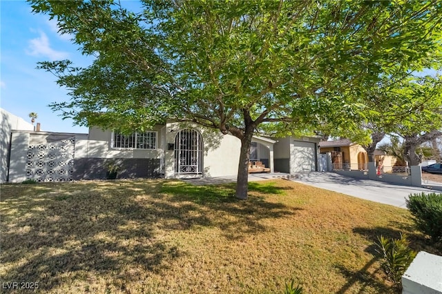 view of property hidden behind natural elements featuring a garage, concrete driveway, a fenced front yard, a front lawn, and stucco siding