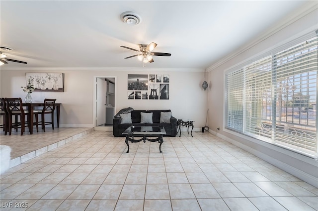 living room with baseboards, visible vents, a ceiling fan, crown molding, and light tile patterned flooring