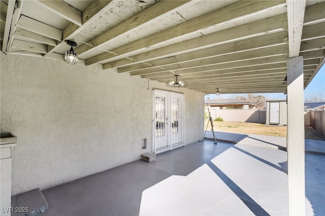 view of patio / terrace with a storage unit and fence