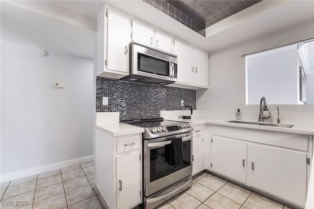 kitchen featuring stainless steel appliances, white cabinets, light countertops, and a sink