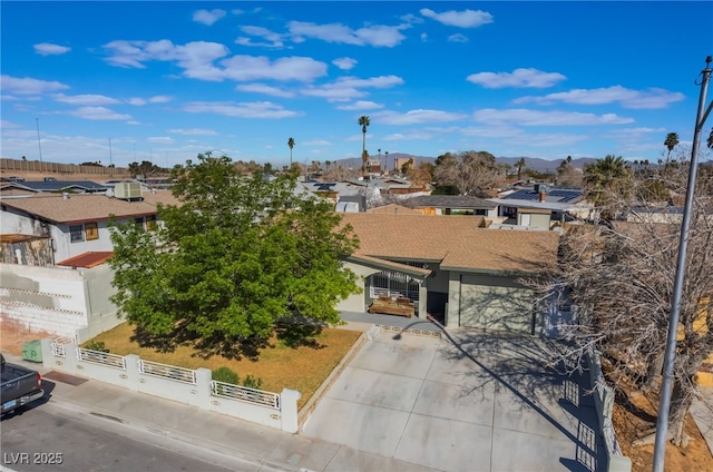 view of front of home with a fenced front yard, a gate, a residential view, and concrete driveway