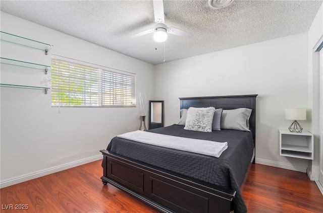 bedroom featuring dark wood-style floors, ceiling fan, baseboards, and a textured ceiling